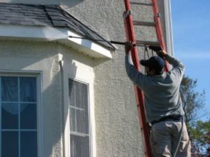 contractor cleaning window of house