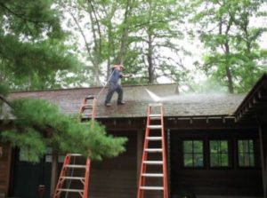 worker cleaning a roof